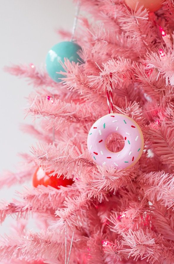 a pink Christmas tree with colorful ornaments and pink donut ornaments is a fun and cool idea for a glam space