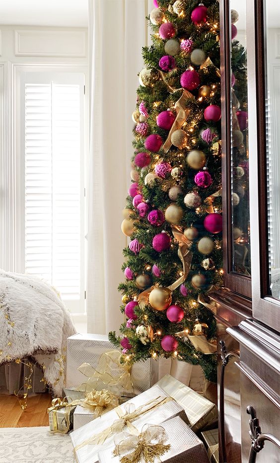 a refined Christmas tree with lights, gold and hot pink and fuchsia ornaments and ribbons is a gorgeous idea for a chic holiday space