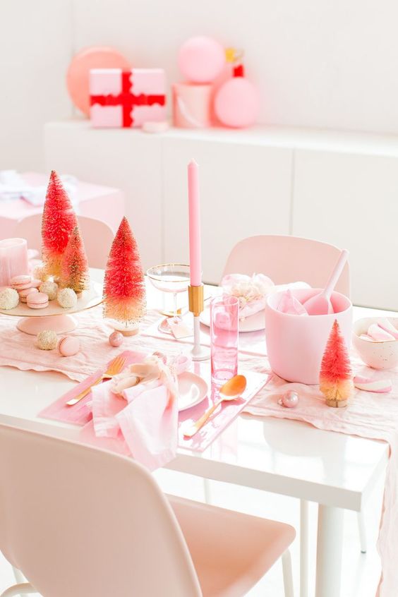 a simple and modern pink Christmas tablescape with light pink linens, candles, acrylic chargers, ornaments and ombre tinsel trees