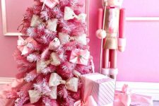 a tabletop pink Christmas tree decorated with gift boxes and bows looks cool and cute and can be used anywhere