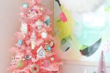 a tabletop pink Christmas tree with lights, pastel and silver food-themed ornaments and a pink snowflake on top
