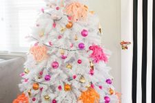 a white Christmas tree with hot pink, fuchsia, gold and orange ornaments and bright tassels is all about modern decor and bright colors