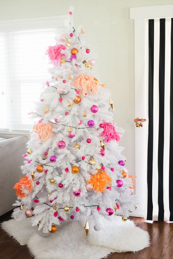 a white Christmas tree with hot pink, fuchsia, gold and orange ornaments and bright tassels is all about modern decor and bright colors