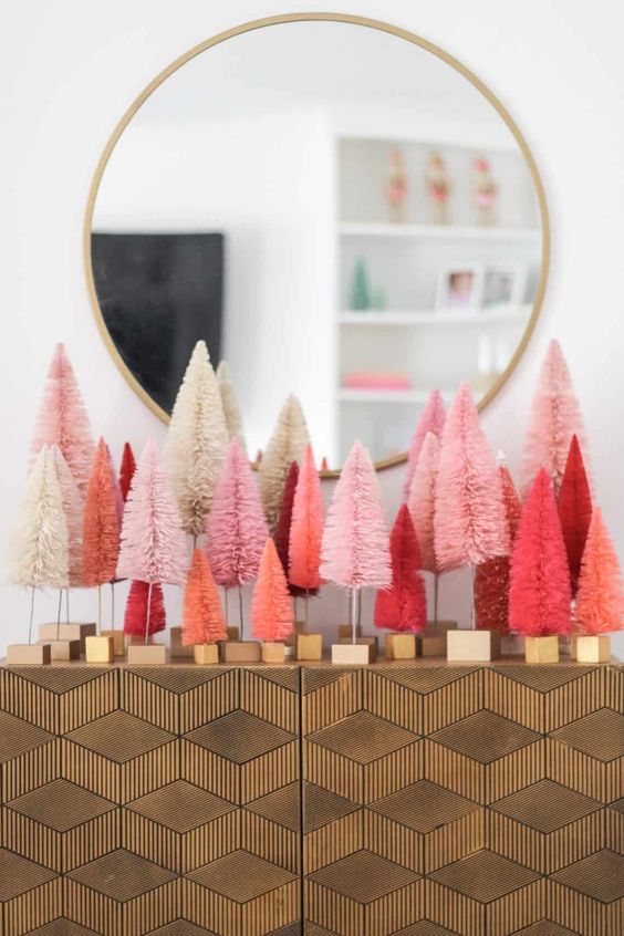 an arrangement of coral and pink and red tinsel Christmas trees on your console table will give a modern festive feel to the entryway