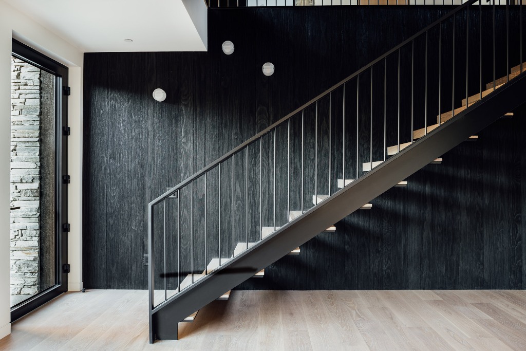 Dark-stained accoya lines the wall behind the staircase