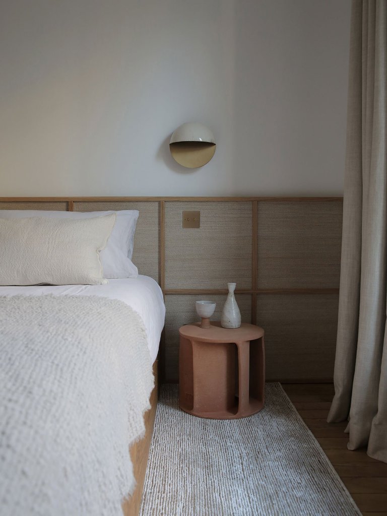 04 The bedroom is very relaxing and calm, with wooden panels, terracotta nightstands, wall sconces