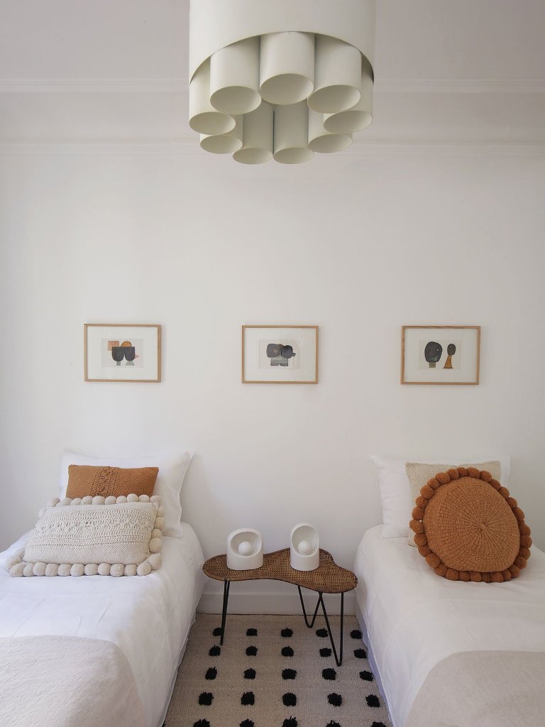 05 The guest bedroom shows off a woven table, a cool tube chandelier and some bright touches