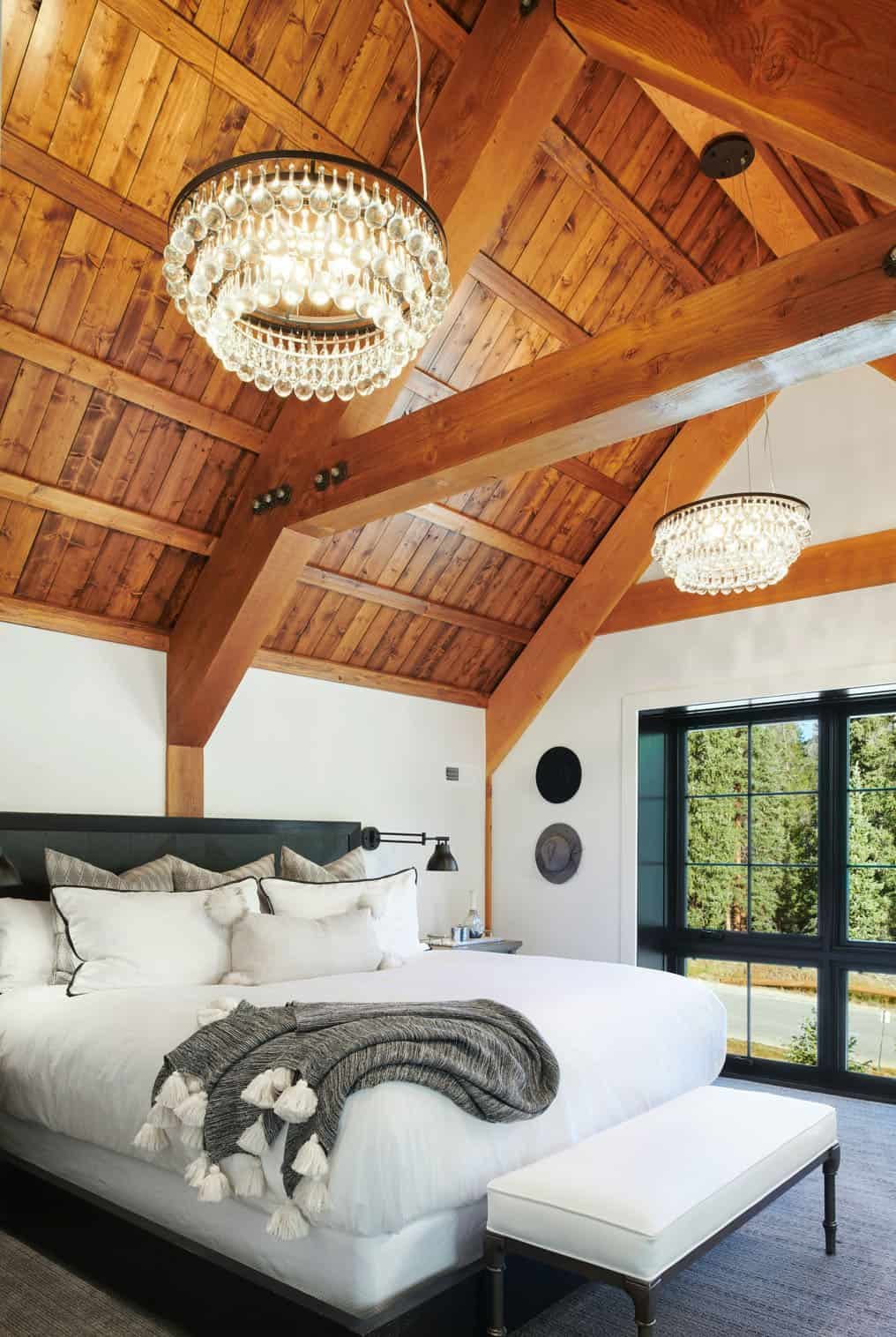 The bedroom features a slanted ceiling accent with crystal chandeliers and cool views
