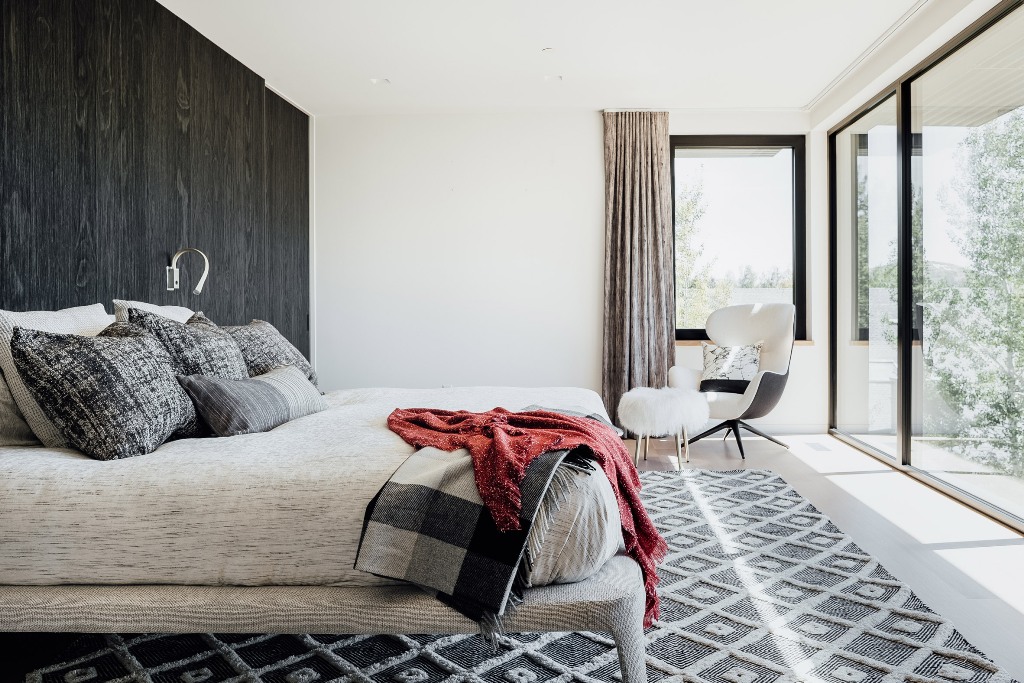 08 The bedroom shows off a timber accent wall, grey and white furniture and decor and an access to the terrace
