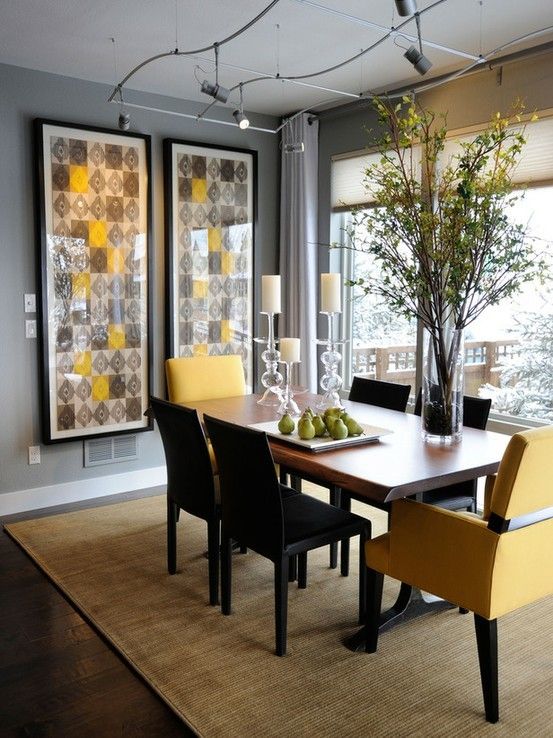 a bold modern dining room with grey walls, a panoramic view, bold artworks, a dining table, black and yellow chairs and catchy lights