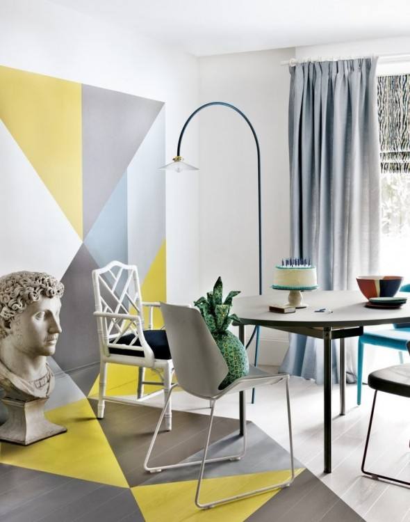 a bright dining room done with geometric color blocj, grey and white chairs, a modern table and a catchy floor lamp