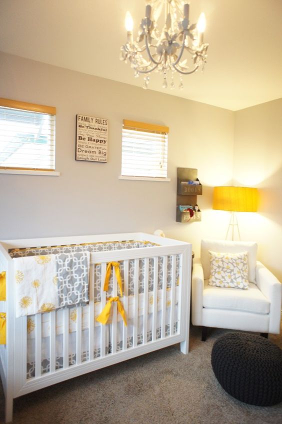 a cozy nursery with grey walls, white furniture, yellow touches and a crystal chandelier plus printed textiles