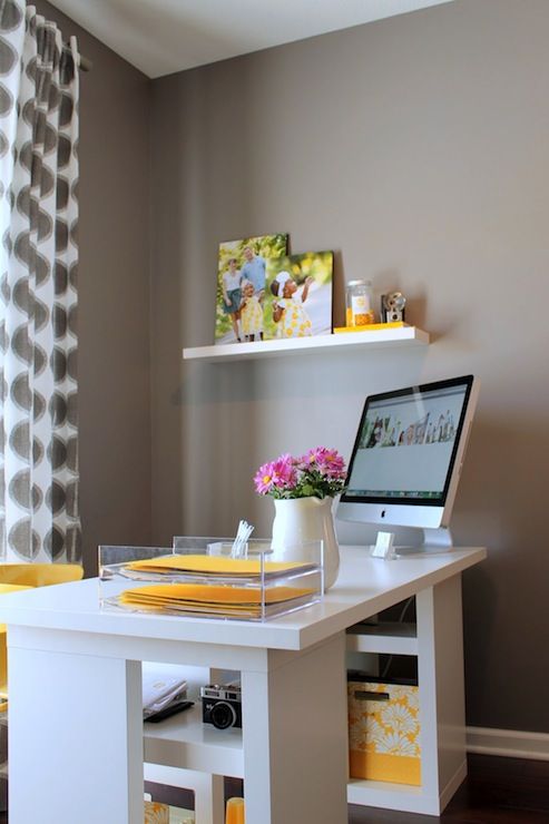 a modern home office with grey walls, a white desk with yellow touches and a yellow chair, printed grey curtains is simple and cool