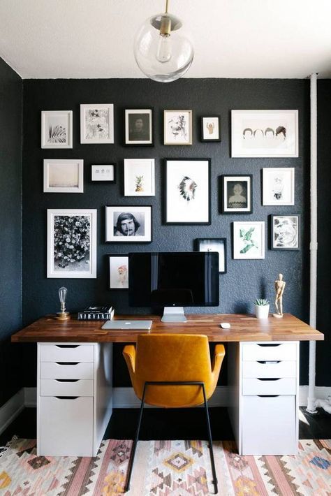 a refined mid century modern home office with a graphite grey wall with a black and white gallery wall, a desk, a yellow leather chair