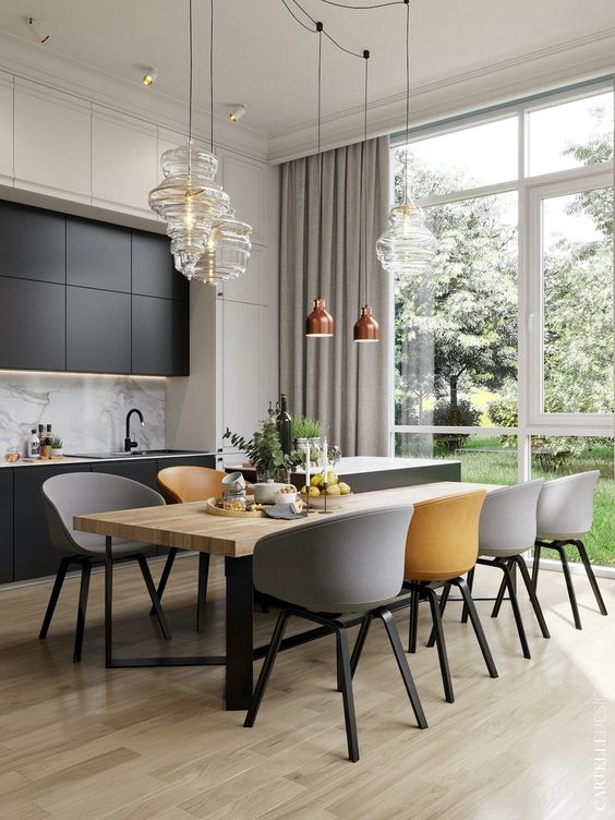 an elegant dining zone with a wooden table, grey and yellow chairs, glass and copper pendant lamps is very chic