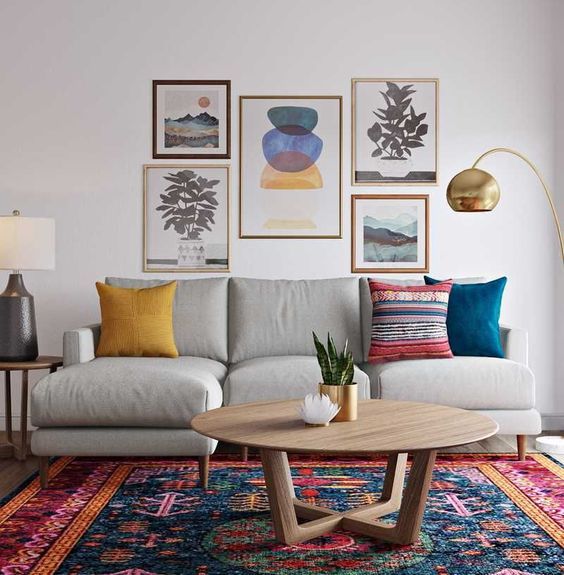 a colorful global style living room with a bold rug, a gallery wall with bright artworks and colorful pillows