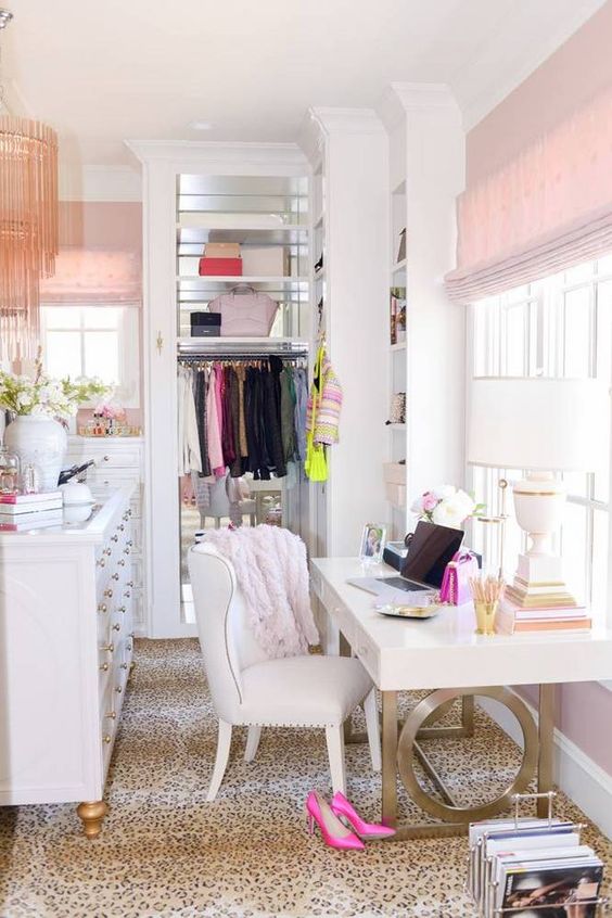 a glam girlish closet that doubles as a home office, decorated with leopard, pink touches and some brass is chic
