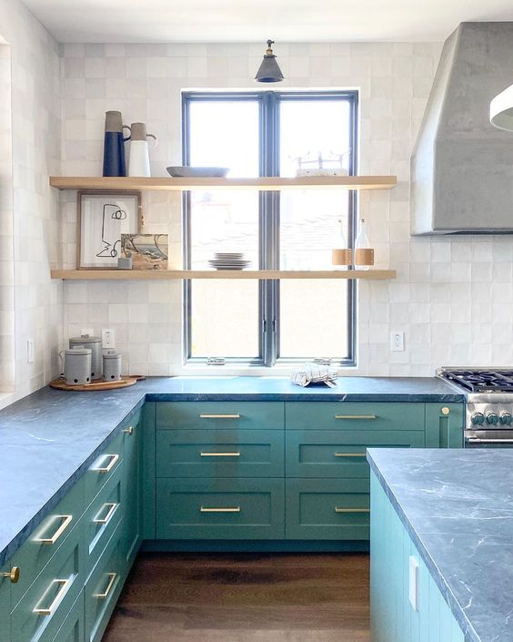 a non-typical shade of green plus grey stone countertops make the kitchen look unusual and very bold