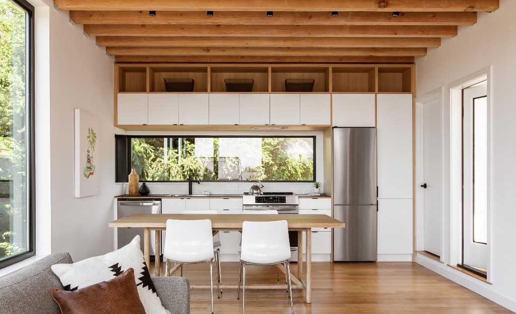 The open layout shows a kitchen, dining space and living room, there's much natural light and an airy feeling