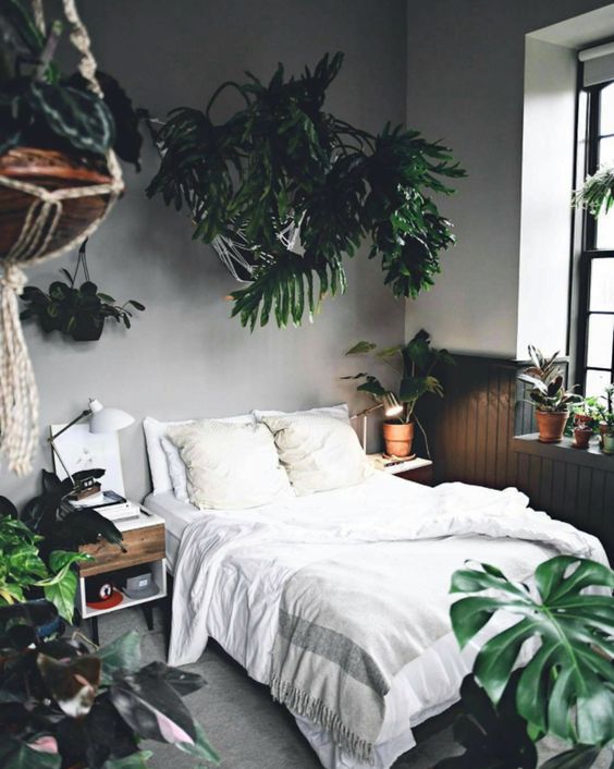A boho bedroom with statement tropical plants in pots feels very welcoming and very summer like