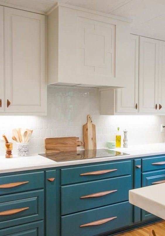 A white and peacock blue kitchen is a very eye catchy idea, unusual wooden handles add to the space and make it wow