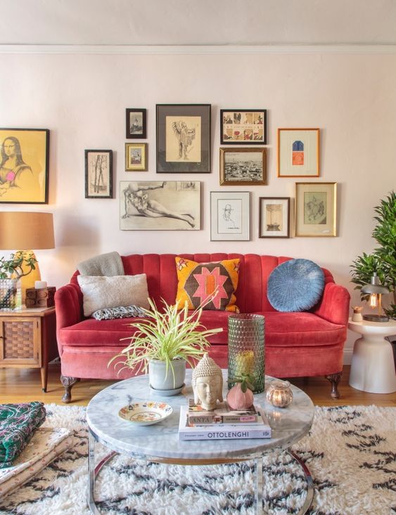 a colorful global bohemian living room with a pink sofa, colorful pillows and a gallery wall with bright artworks