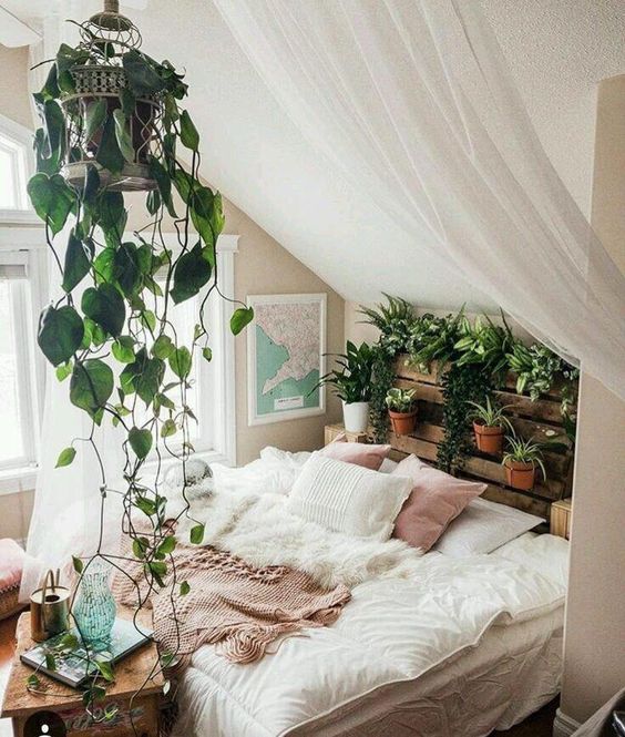 an attic boho bedroom with a pallet headboard garden and a suspended cage with greenery is gorgeous