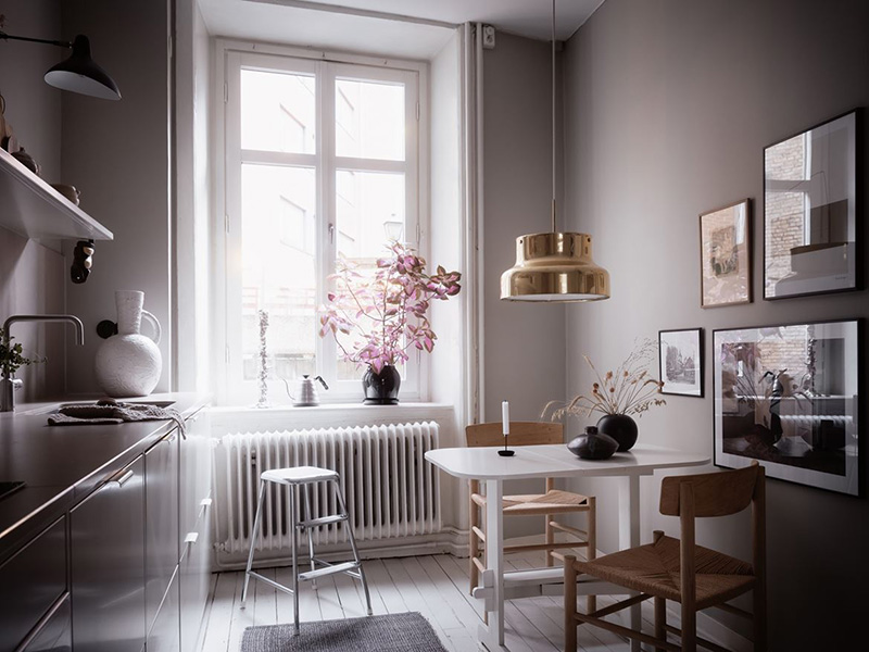 A tiny breakfast space is located by the window and accented with a gold pendant lamp