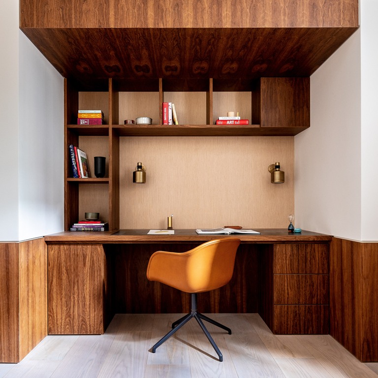 There's a working space built into a corner, with a desk, a storage unit and a ceiling