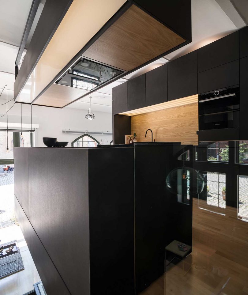 A hood over the island contains built in lights and storage space, too, and finishes the look of the space