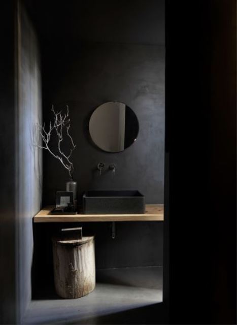 09 a beautiful minimalist black bathroom with matte walls, a floating vanity, a tree stump and a round mirror