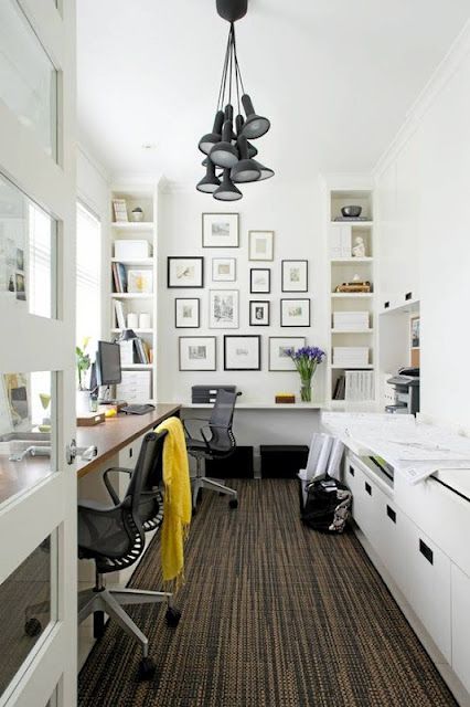 a cool shared Scandinavian home office with a shared desk, chairs, pendant lamps, sleek storage units and a gallery wall
