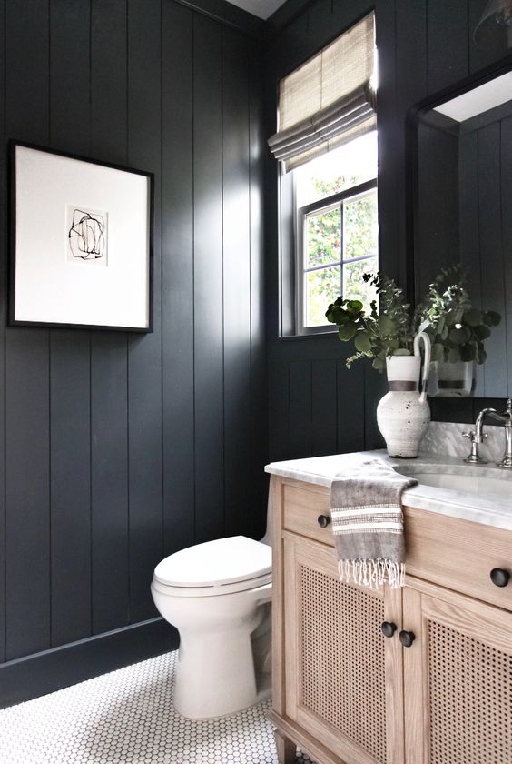 11 a black bathroom with beadboard walls, a white scale tile floor and a wooden vanity is a very cozy and welcoming space