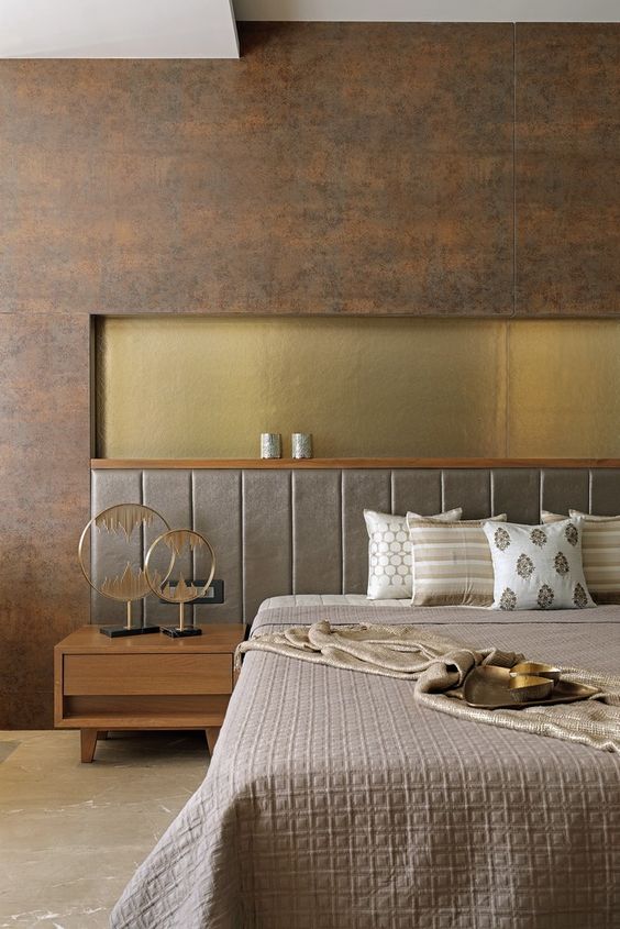12 a luxurious bedroom in earthy tones, with a rust metal accent wall, an upholstered grey bed, a gold insert and elegant bedding