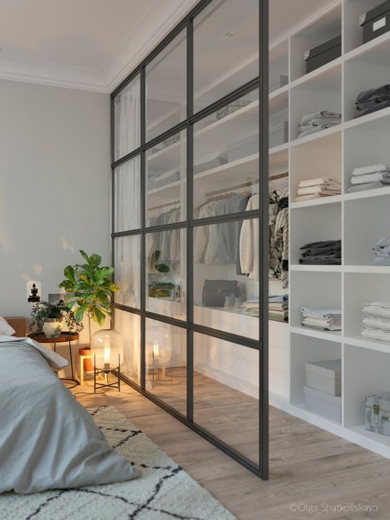 12 a modern bedroom and a closet separated with a French window divider looks airy and chic and features storage space here