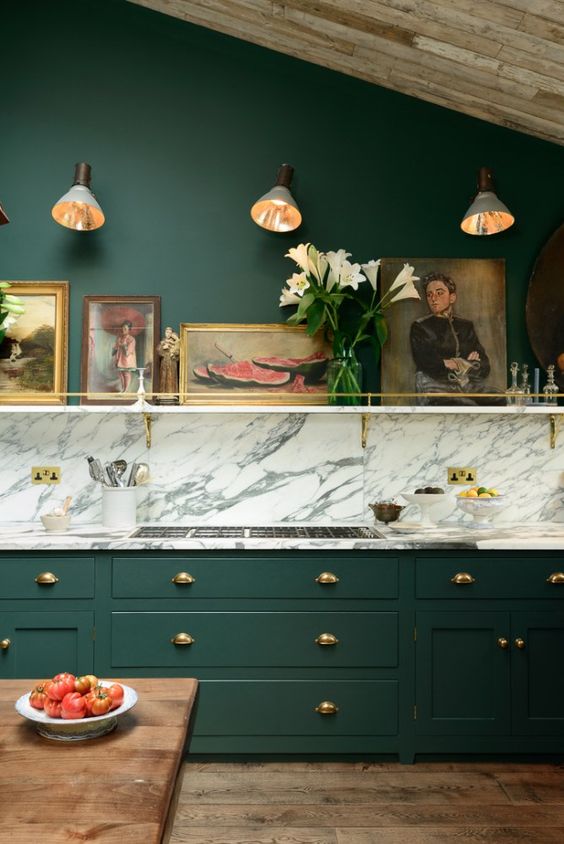 12 a vintage hunter green kitchen with a white marble backsplash and countertops, a shelf with artworks is chic