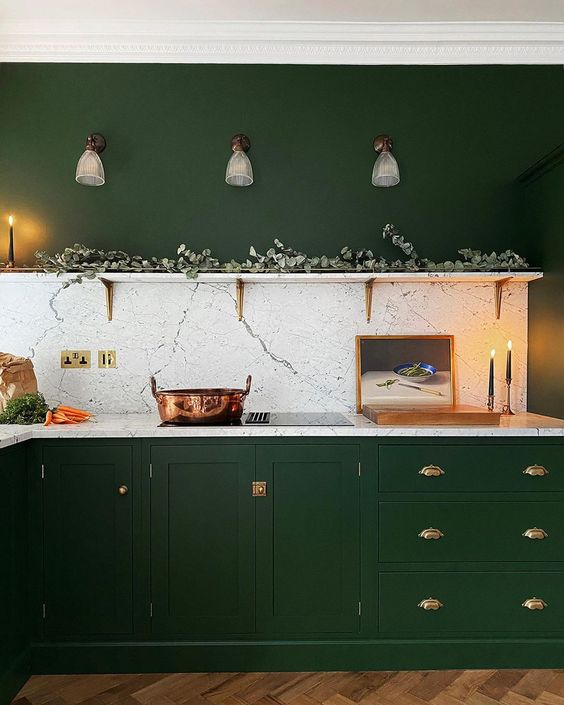 13 a hunter green kitchen with vintage cabinets, gold handles, an open shelf with greenery and a white stone backsplash