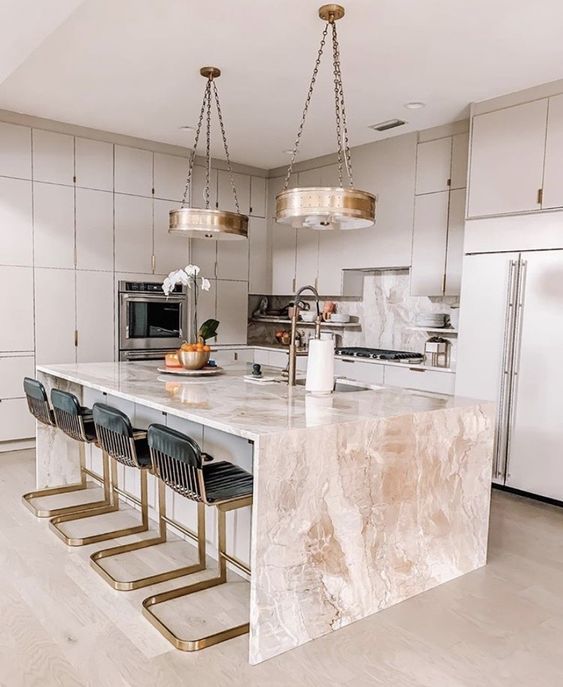 13 an elegant dove grey kitchen with a pink stone kitchen island, whimsy black and gold stools and gold pendant lamps