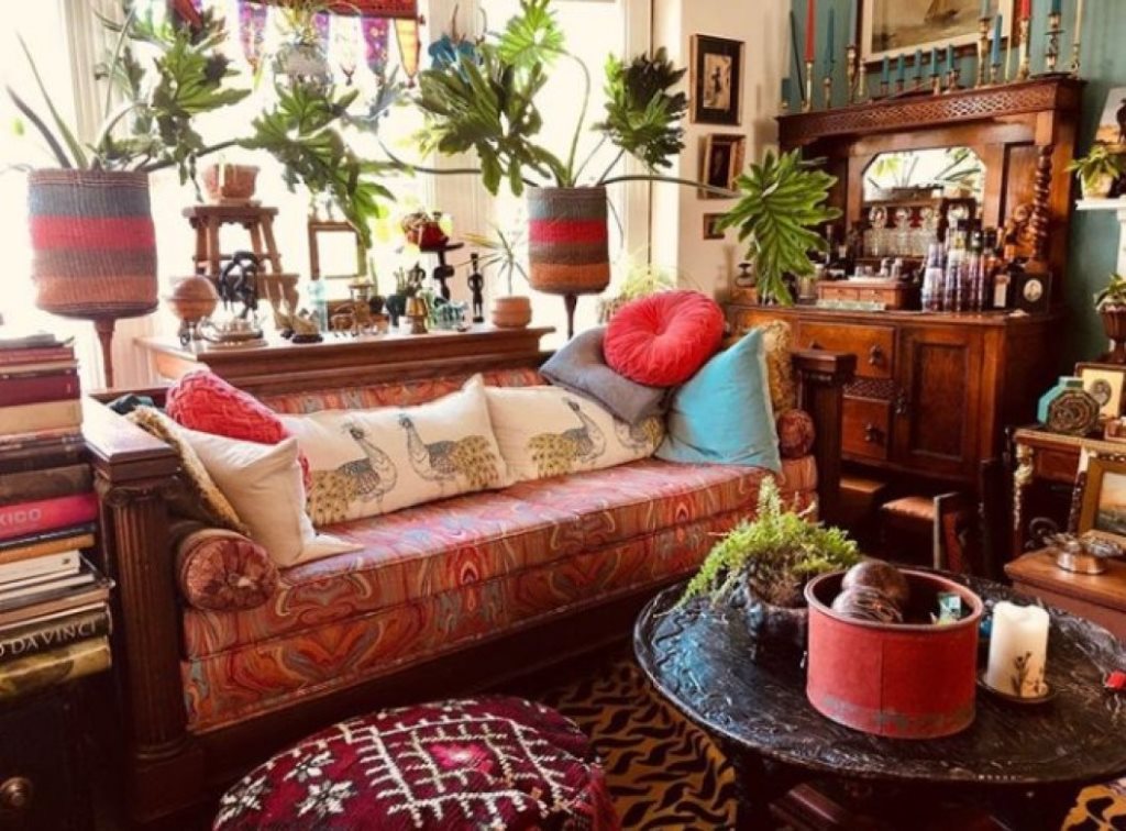 14 a bright maximalist living room with heavy vintage furniture, colorful textiles, colorful pillows and potted plants