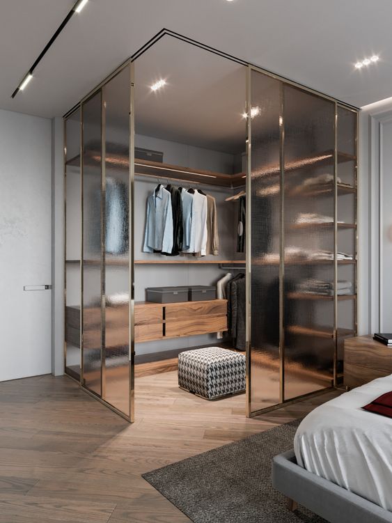 a masculine bedroom with a corner closet enclosed in frosty glass is a stylish and very modern idea to rock