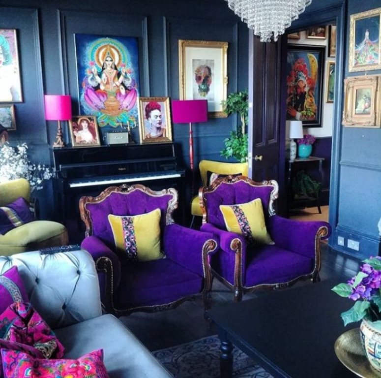 15 a bold maximalist living room with blue walls, pink and purple furniture, colorful artworks and potted plants