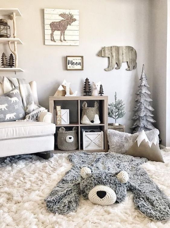 A neutral woodland nursery with wooden decorations and a faux bear skin plus animal shaped baskets