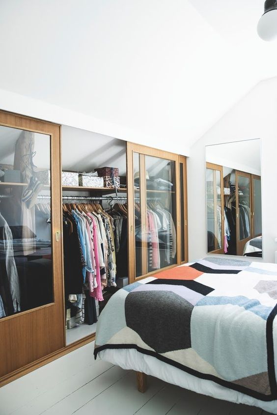 15 a small attic bedroom in neutrals, with its awkward part covered with sliding glass doors and used as a closet