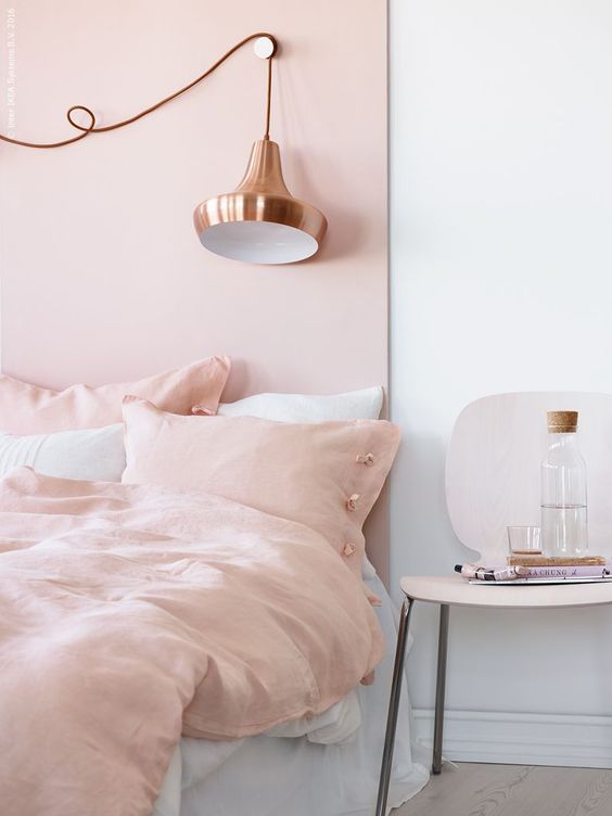 15 a welcoming and inviting bedroom with a blush accent wal and matching bedding plus a copper lamp