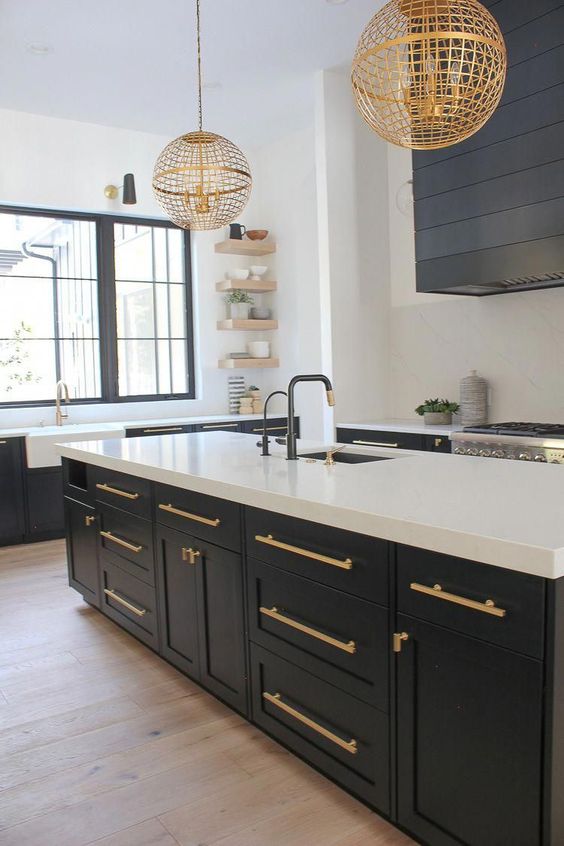 a contrasting graphite grey and white kitchen with gold handles and matching gold globe pendant lamps looks chic