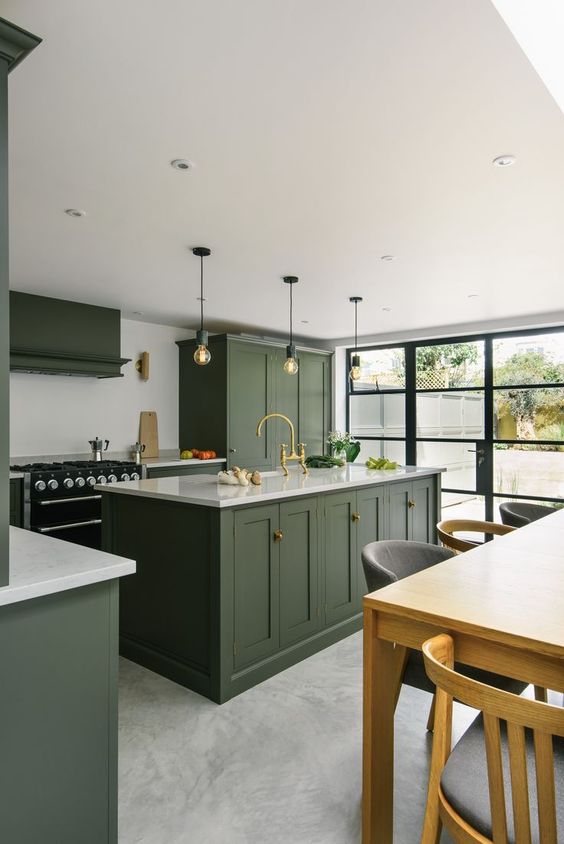 18 a stylish hunter green kitchen with vintage cabinetry, a white backsplash and countertops, pendant bulbs and a glazed wall