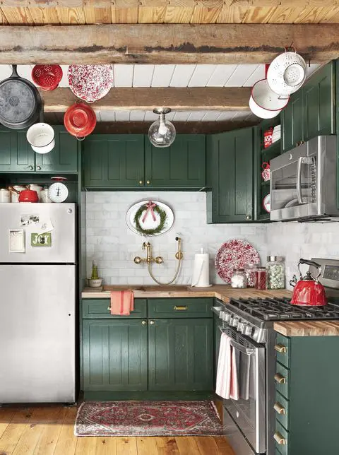 19 a pretty hunter green kitchen with butcherblock countertops and a white marble tile backsplash plus wooden beams on the ceiling