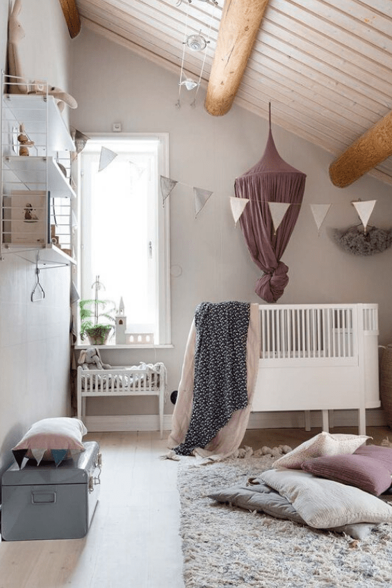 an attic neutral and pastel hygge nursery with modern furniture, pastel textiles and some prints is very welcoming