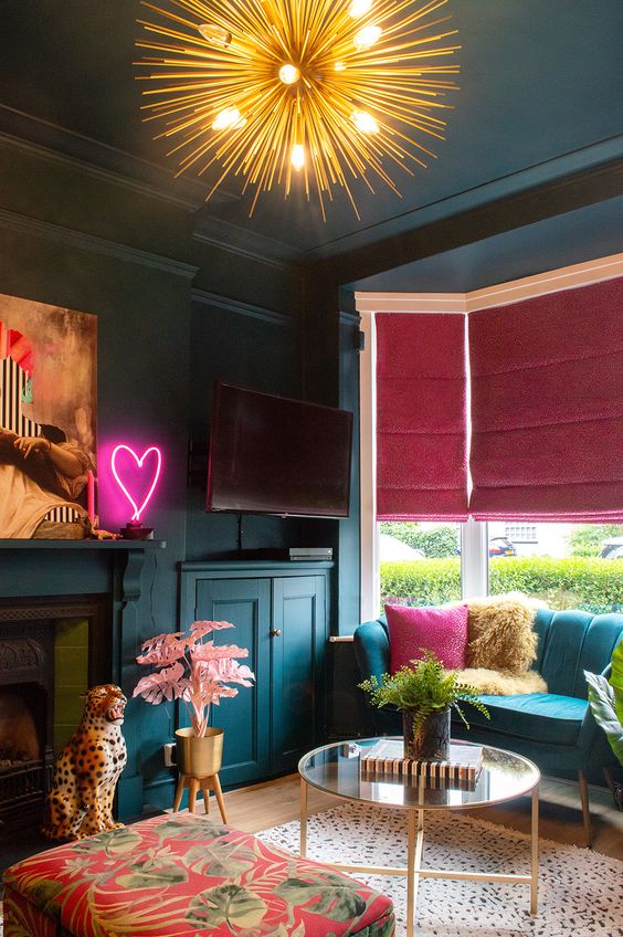 20 a moody maximalist living room with teal walls and furniture, a fireplace, pink and fuchsia touches and neon light