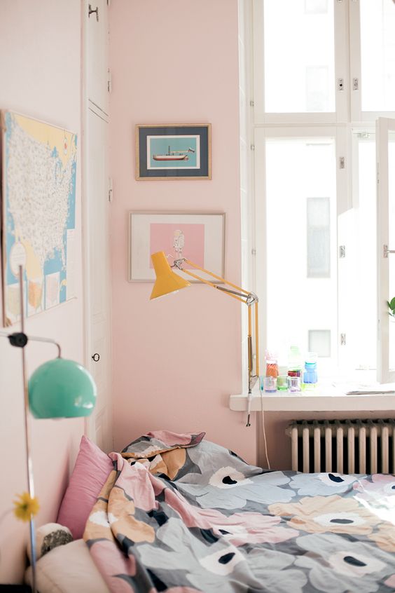 a bedroom with pink walls, artworks, floral bedding and colorful lamps is amazing for spring and summer